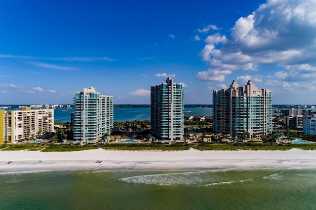 drone / aerial view featuring a city view, a water view, and a beach view