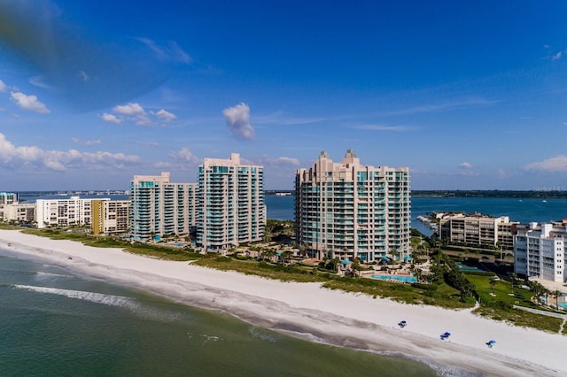 drone / aerial view featuring a view of city, a water view, and a view of the beach