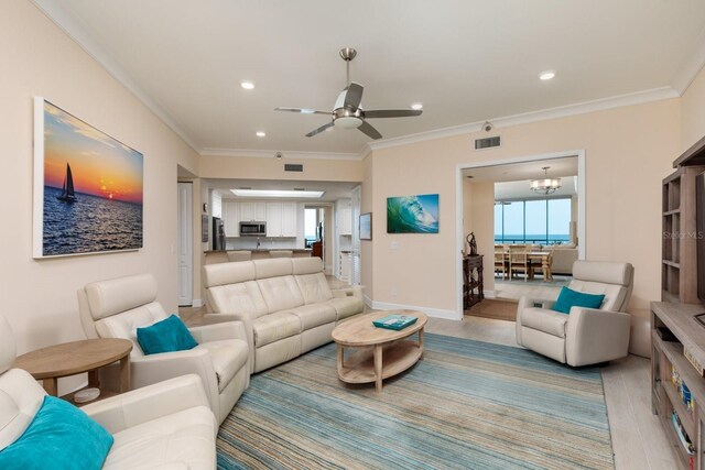 living room featuring recessed lighting, visible vents, crown molding, and light wood-style flooring