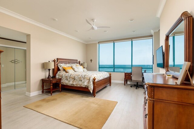 bedroom featuring light wood-style flooring, ornamental molding, ceiling fan, and baseboards