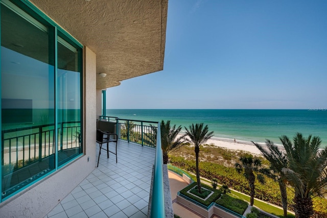 balcony with a water view and a beach view