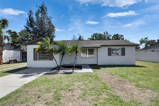 ranch-style home featuring fence, a front lawn, and stucco siding