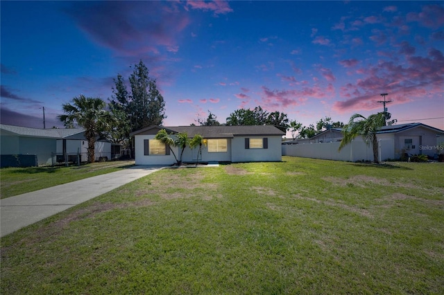 view of front of house with driveway, fence, and a front lawn