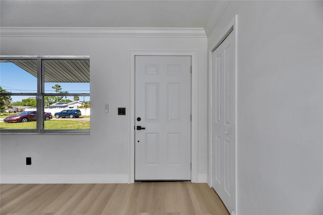 interior space with light wood finished floors, baseboards, and ornamental molding