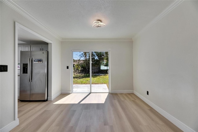 doorway featuring light wood-type flooring, crown molding, and a textured ceiling