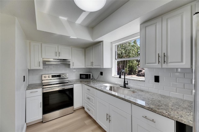 kitchen featuring stainless steel electric range oven, light wood finished floors, white cabinets, a sink, and under cabinet range hood