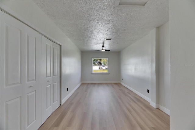 unfurnished dining area with light wood finished floors, baseboards, visible vents, and a textured ceiling