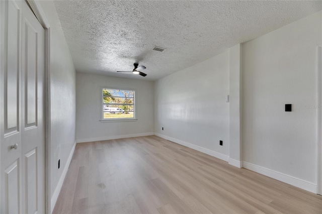 empty room featuring light wood-style flooring, visible vents, and baseboards