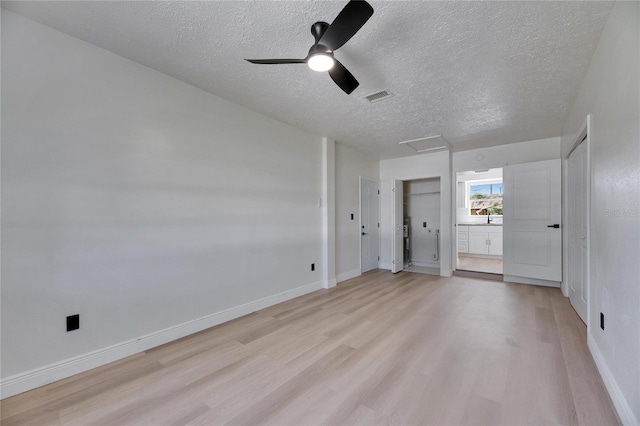 unfurnished bedroom with attic access, visible vents, light wood-style floors, and baseboards