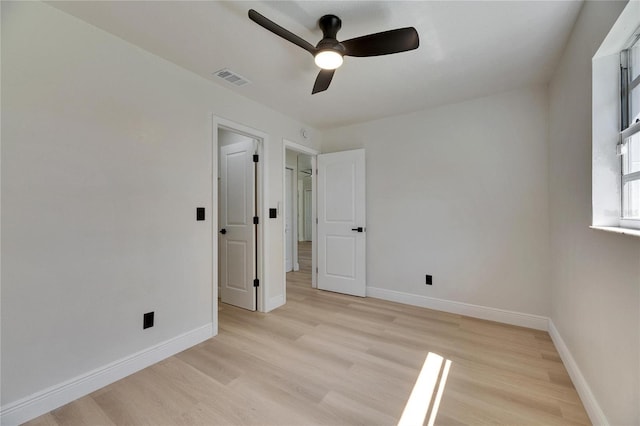 unfurnished bedroom with light wood finished floors, baseboards, visible vents, and a ceiling fan