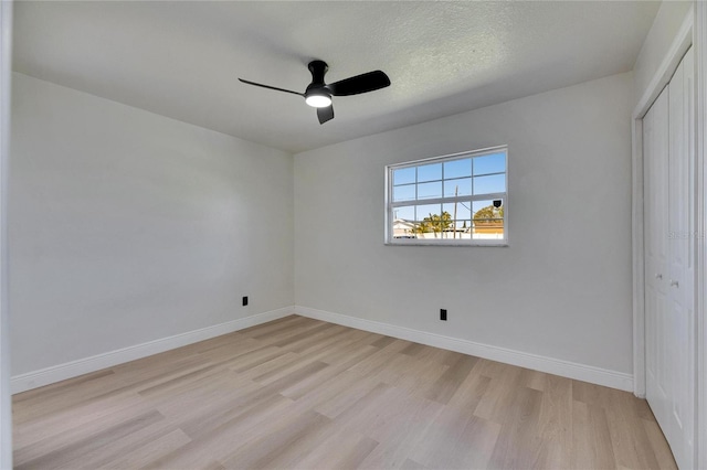 unfurnished bedroom with a ceiling fan, a closet, baseboards, and light wood finished floors