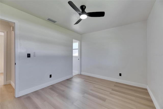 unfurnished room with light wood-type flooring, visible vents, and baseboards