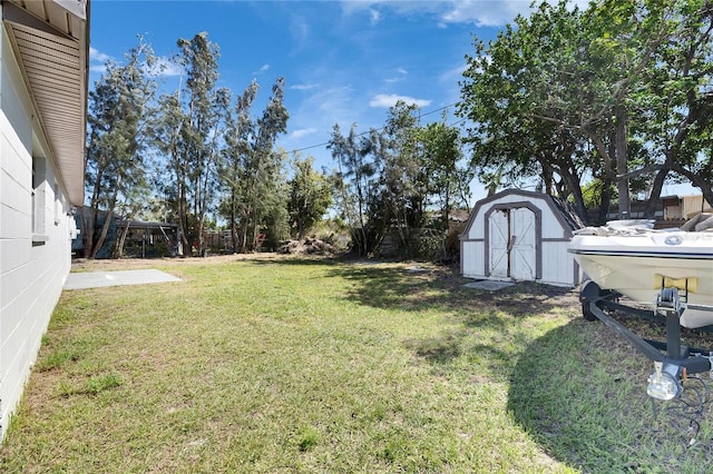 view of yard with a fenced backyard, an outdoor structure, and a storage unit