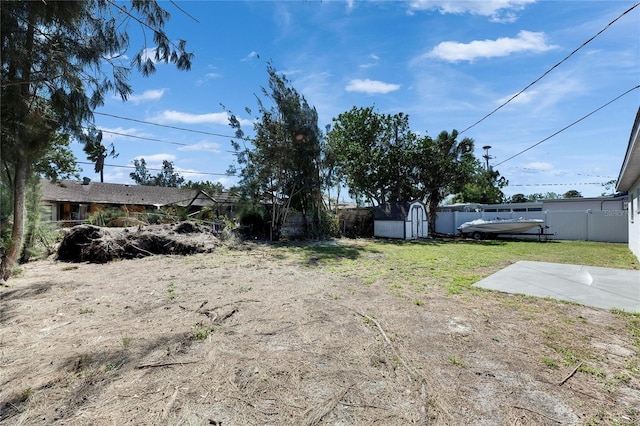 view of yard featuring a fenced backyard, an outdoor structure, and a shed