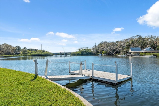 dock area with a yard and a water view