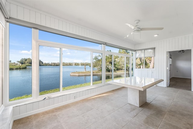 unfurnished sunroom with a water view and ceiling fan