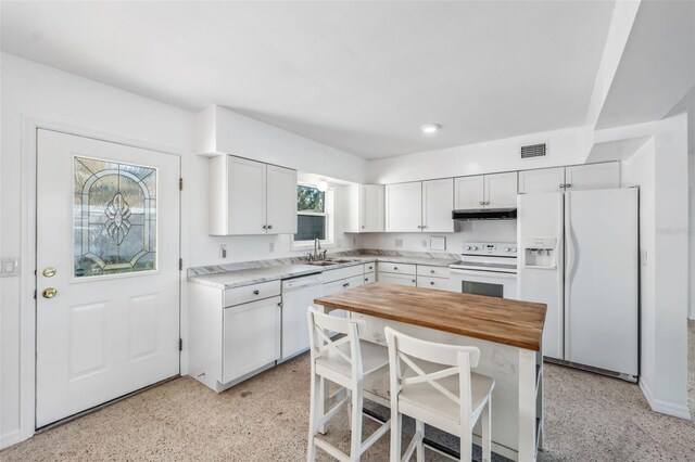 kitchen with visible vents, wooden counters, under cabinet range hood, white appliances, and white cabinetry