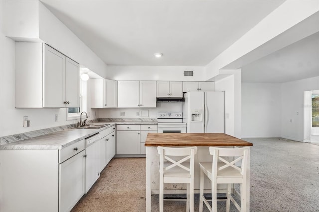 kitchen featuring a healthy amount of sunlight, under cabinet range hood, white appliances, white cabinetry, and a sink