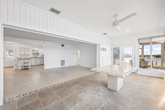 interior space with visible vents, french doors, ceiling fan, and a sink