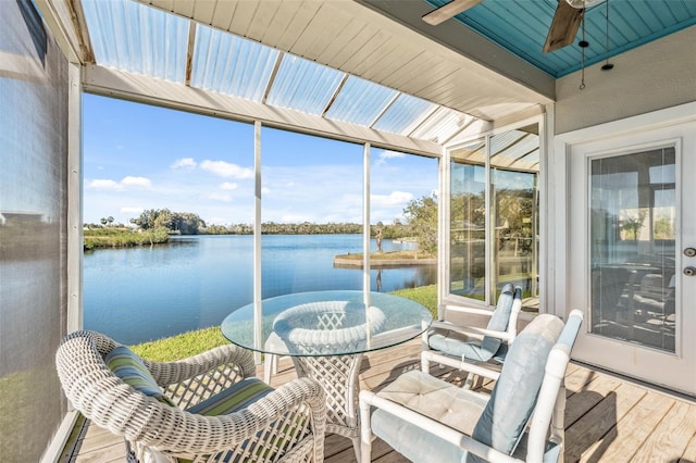 sunroom featuring plenty of natural light, a ceiling fan, and a water view