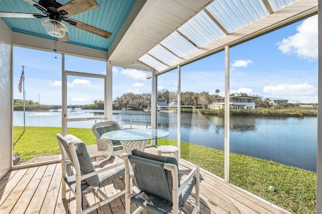 sunroom / solarium with a water view and a ceiling fan