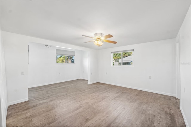 empty room with a ceiling fan, baseboards, and wood finished floors