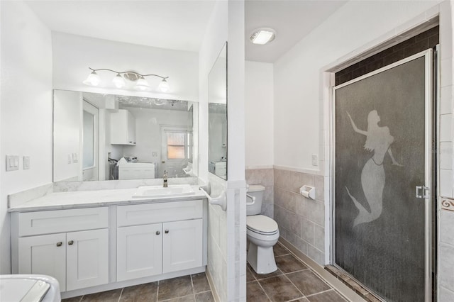 bathroom with wainscoting, toilet, a stall shower, and tile walls