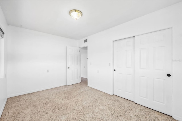 unfurnished bedroom with speckled floor, visible vents, a closet, and baseboards