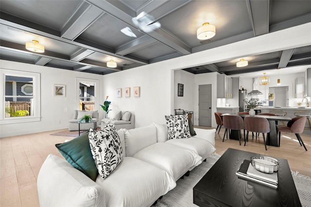 living area featuring coffered ceiling, beamed ceiling, and light wood finished floors