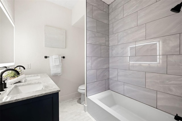 full bath featuring toilet, double vanity, baseboards, and a sink