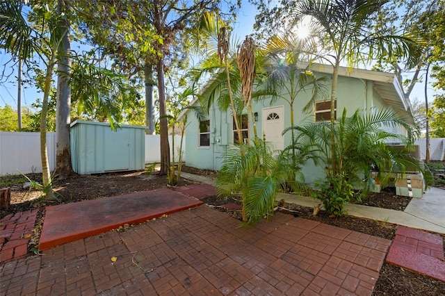 exterior space with an outbuilding, fence, and a storage shed