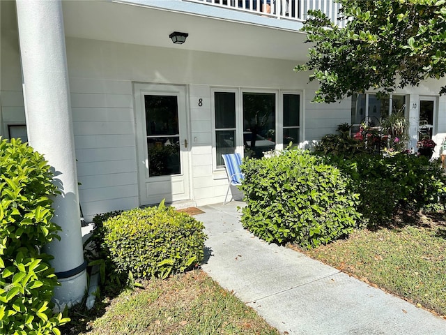 view of exterior entry with a balcony