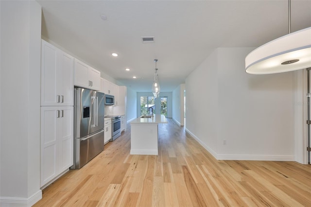 kitchen featuring visible vents, appliances with stainless steel finishes, light wood-style flooring, and white cabinetry