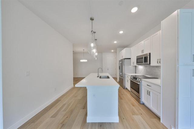 kitchen with an island with sink, white cabinetry, appliances with stainless steel finishes, and a sink