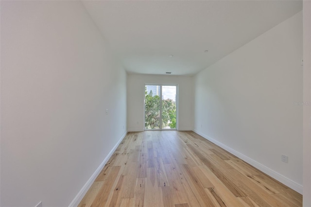 empty room with baseboards and light wood-style floors