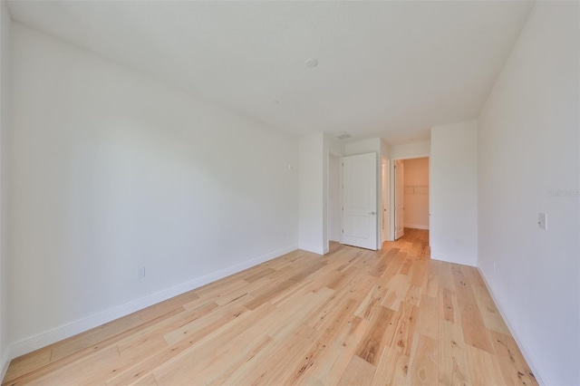 spare room featuring light wood-type flooring and baseboards