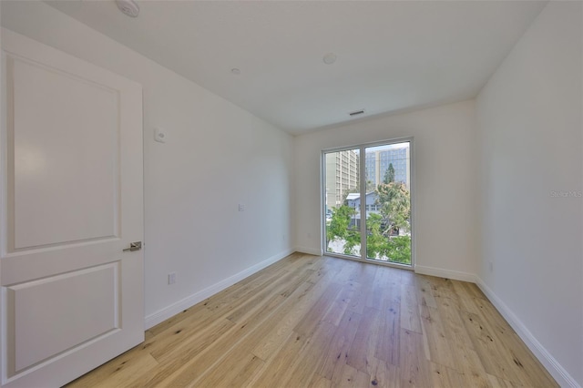 empty room featuring light wood finished floors and baseboards