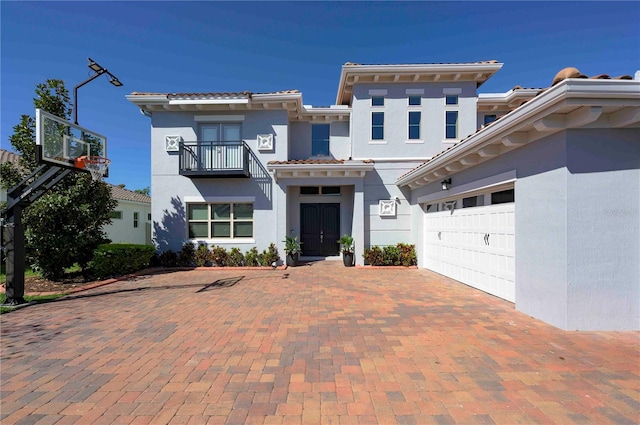 view of front of home featuring a garage, driveway, a tiled roof, and stucco siding