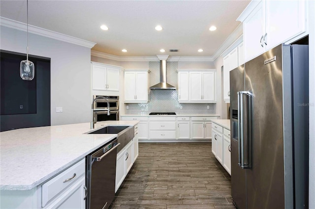 kitchen with backsplash, appliances with stainless steel finishes, dark wood-type flooring, white cabinets, and wall chimney exhaust hood