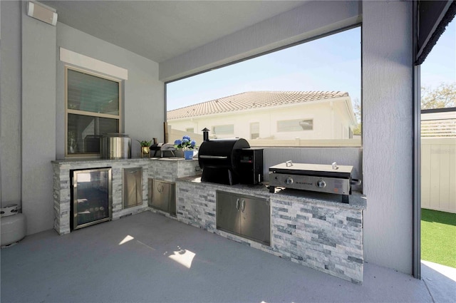 view of patio / terrace featuring exterior kitchen, beverage cooler, and a grill