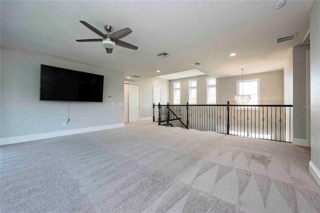 carpeted empty room with baseboards, visible vents, and recessed lighting