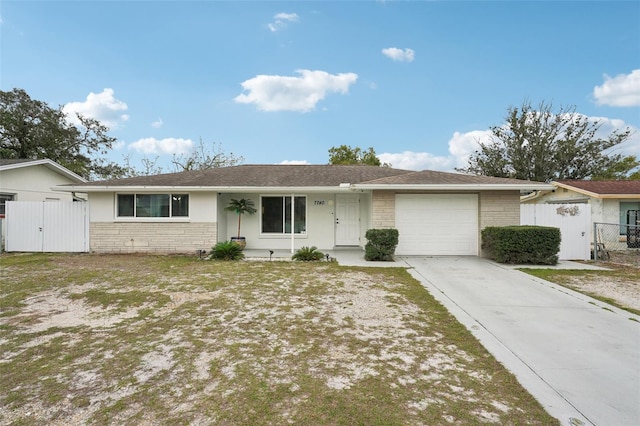 ranch-style home with a garage, concrete driveway, fence, and a gate