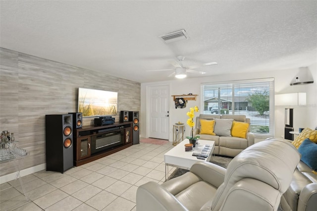 7740 Bracken Dr, Port Richey, FL 34668 - living area with a textured ceiling, light tile patterned flooring, a ceiling fan, visible vents, and baseboards