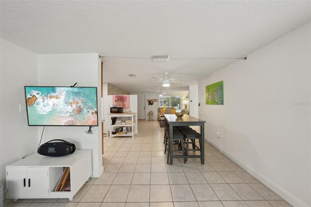 7740 Bracken Dr, Port Richey, FL 34668 - dining area with light tile patterned floors, baseboards, visible vents, a ceiling fan, and a textured ceiling
