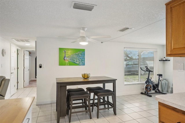 7740 Bracken Dr, Port Richey, FL 34668 - dining area featuring a textured ceiling, light tile patterned flooring, and visible vents