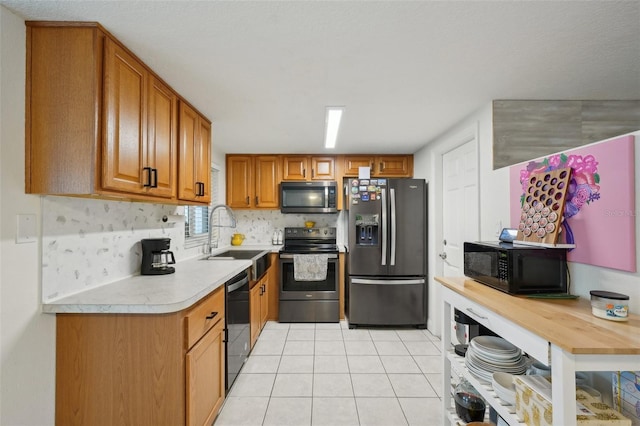 7740 Bracken Dr, Port Richey, FL 34668 - kitchen with a sink, light countertops, appliances with stainless steel finishes, decorative backsplash, and brown cabinets
