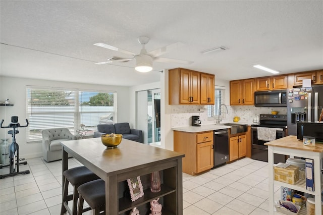 7740 Bracken Dr, Port Richey, FL 34668 - kitchen with light tile patterned floors, stainless steel appliances, tasteful backsplash, light countertops, and a sink