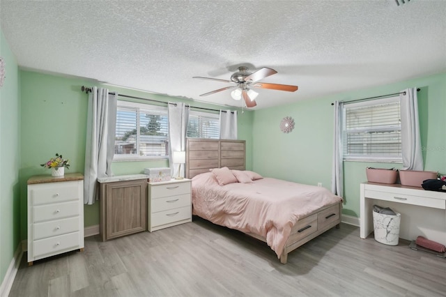 7740 Bracken Dr, Port Richey, FL 34668 - bedroom with light wood-style floors, ceiling fan, baseboards, and a textured ceiling