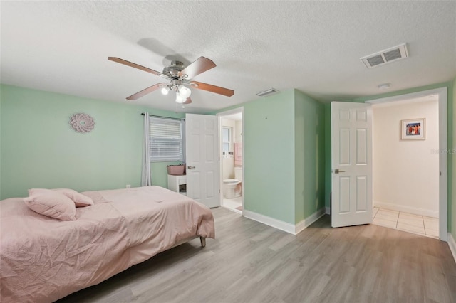 7740 Bracken Dr, Port Richey, FL 34668 - bedroom featuring a textured ceiling, light wood finished floors, visible vents, and baseboards