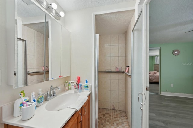 7740 Bracken Dr, Port Richey, FL 34668 - ensuite bathroom with baseboards, connected bathroom, a textured ceiling, vanity, and a shower stall